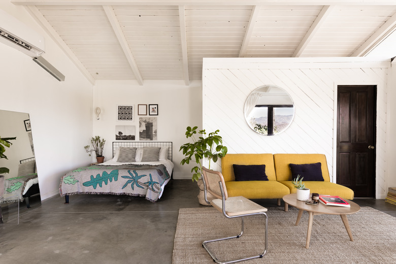 bedroom and accent chairs and concrete flooring