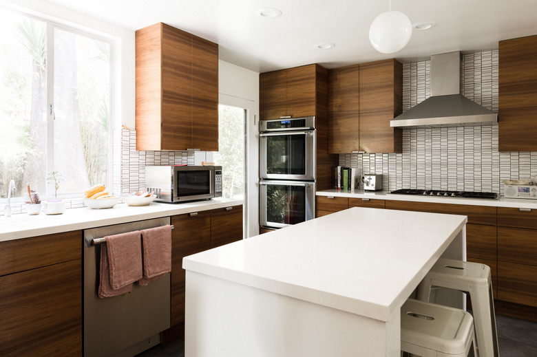 Midcentury kitchen with wood cabinets and white tile backsplash