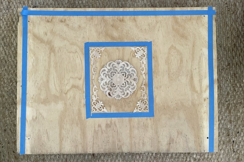 Wood appliqués arranged on top of plywood
