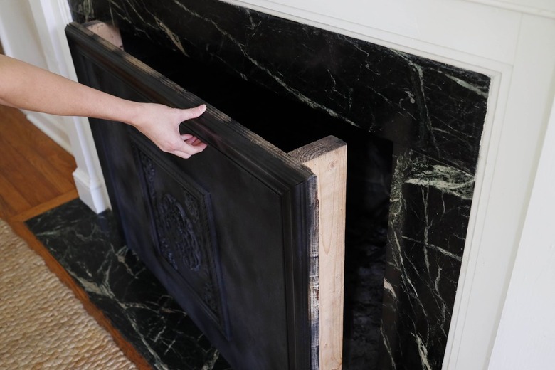 Sliding the fireplace cover into the fireplace opening