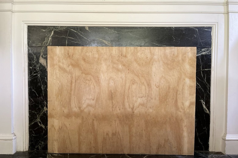 Plywood panel cut to size of fireplace opening