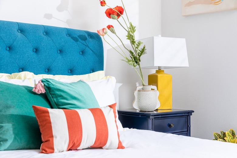 white bedroom with colorful bed and bedding