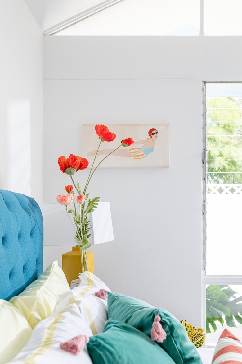 white bedroom with colorful bed and bedding