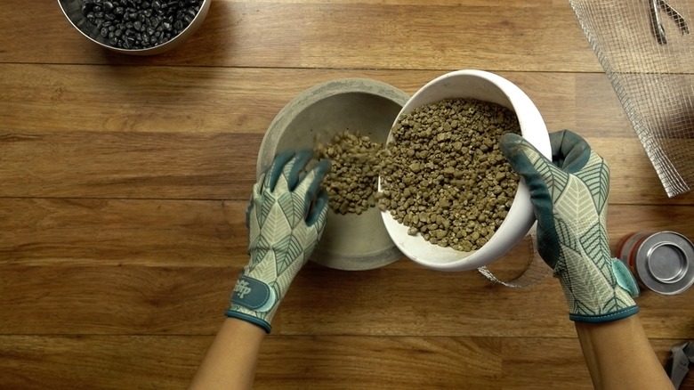 Adding gravel to DIY concrete fire bowl.