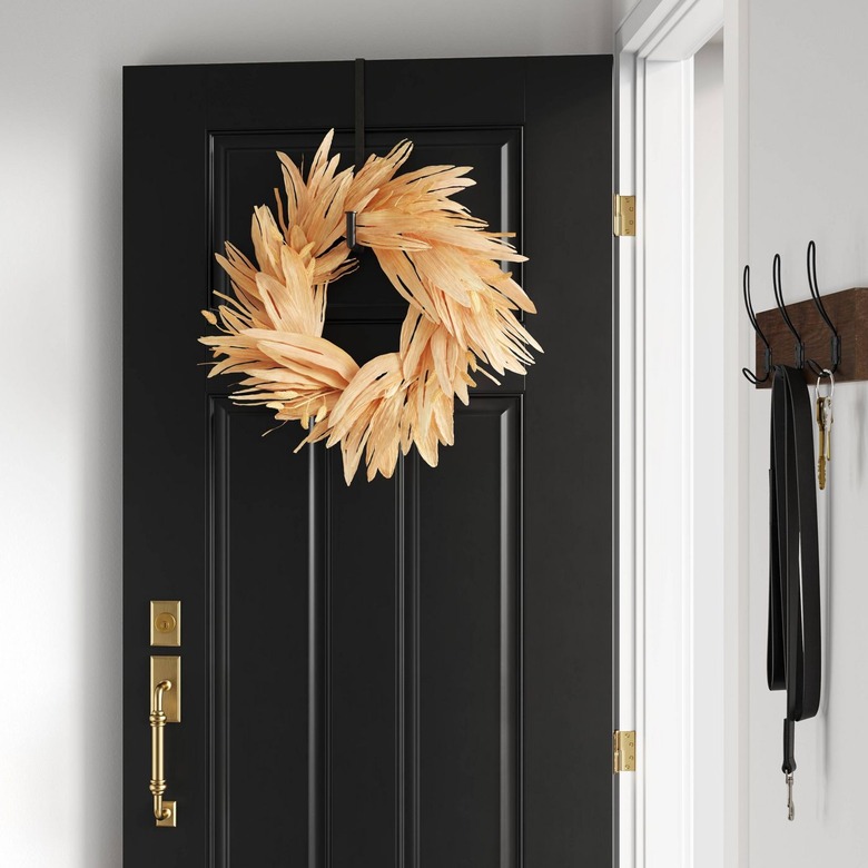black door with artificial corn husk wreath
