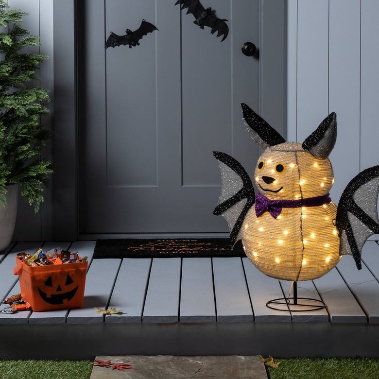 An adorable light-up bat sculpture with a white paper lantern body and head