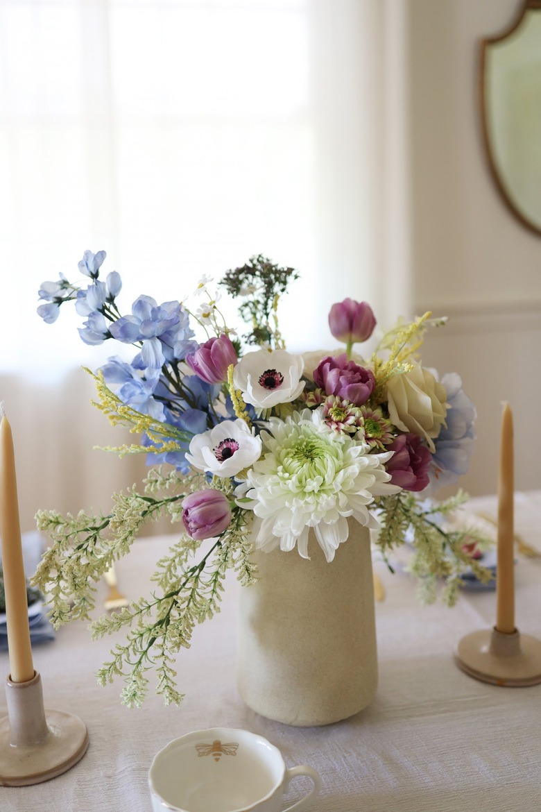 Floral centerpiece in white vase with with blue