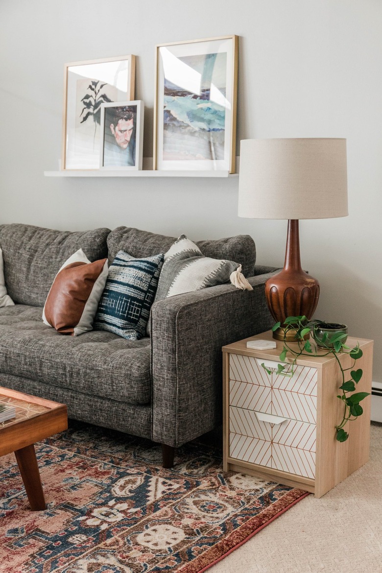 Scandinavian white and neutral nightstand with striped pattern with plant on Persian rug