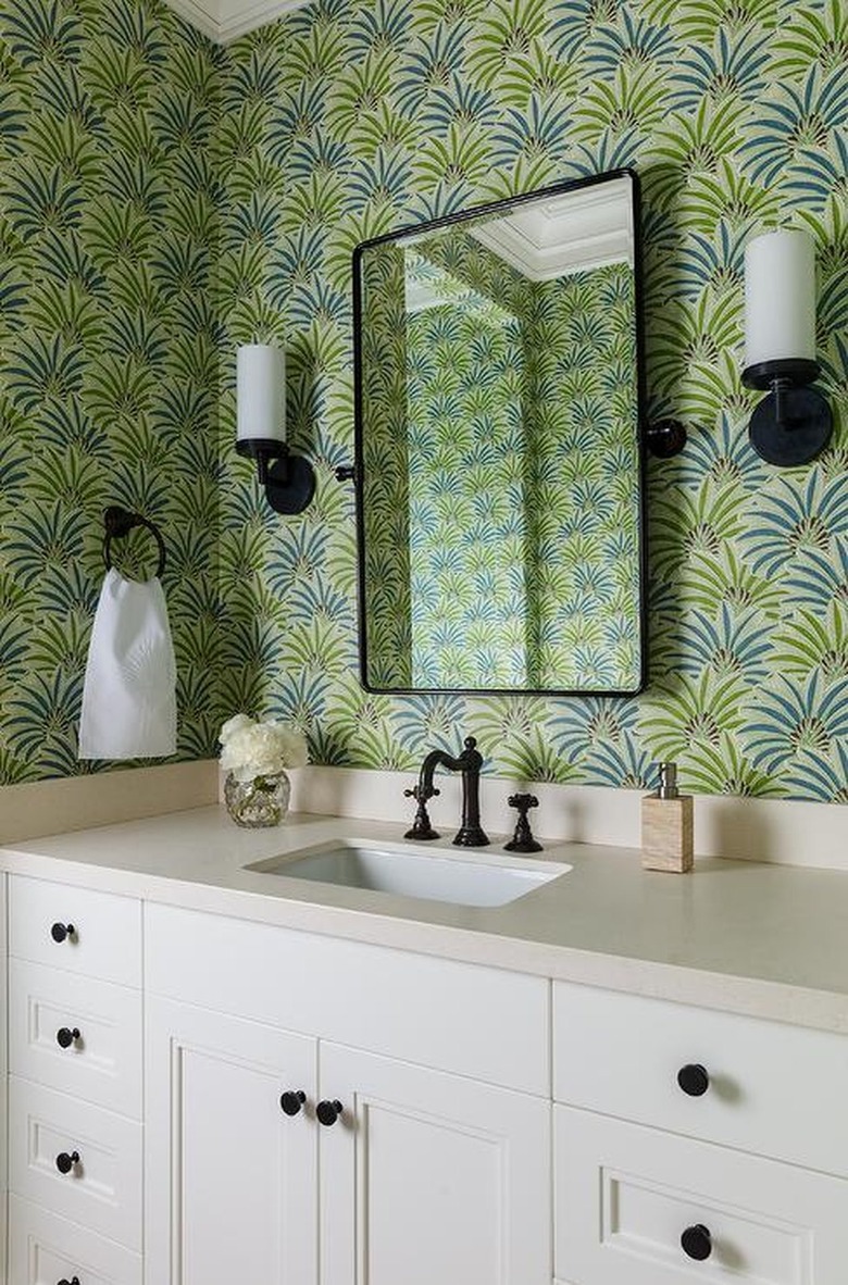 bathroom with lime green patterned wallpaper and bronze fixtures