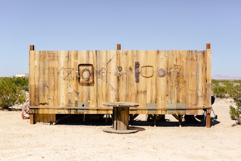 Found objects hang on the exterior of the outdoor kitchen at Saturn.