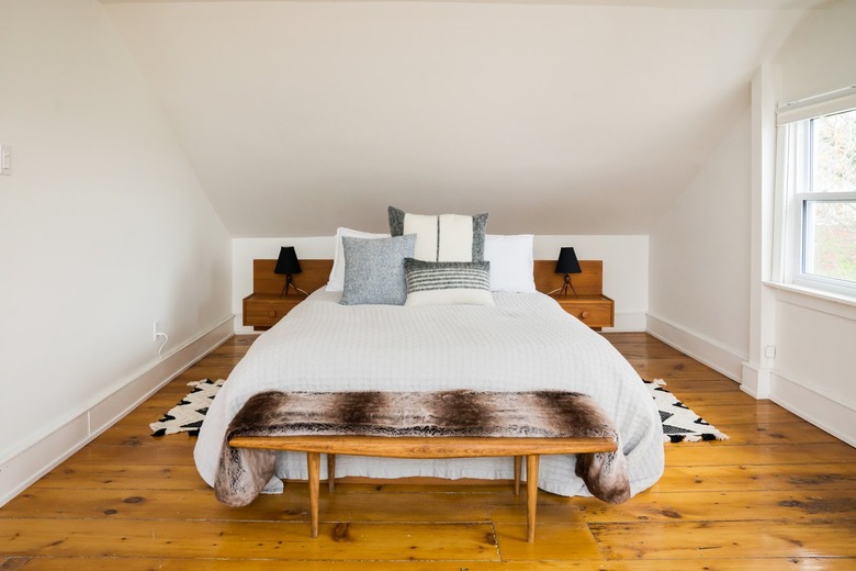 a white bedroom with a rustic wide-plank floor