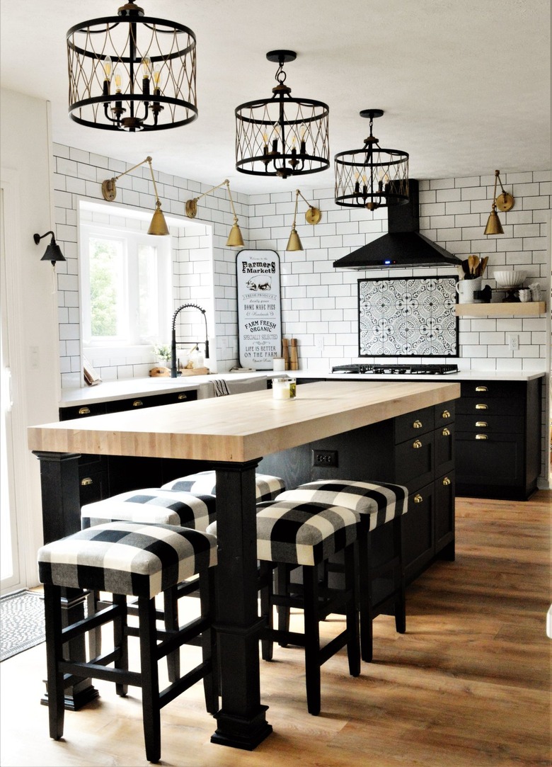 farmhouse kitchen with subway tile backsplash and three black chandeliers