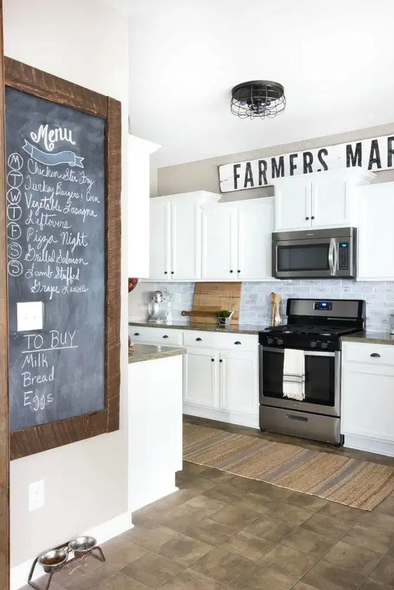 farmhouse kitchen with white cabinets and black cage style ceiling light