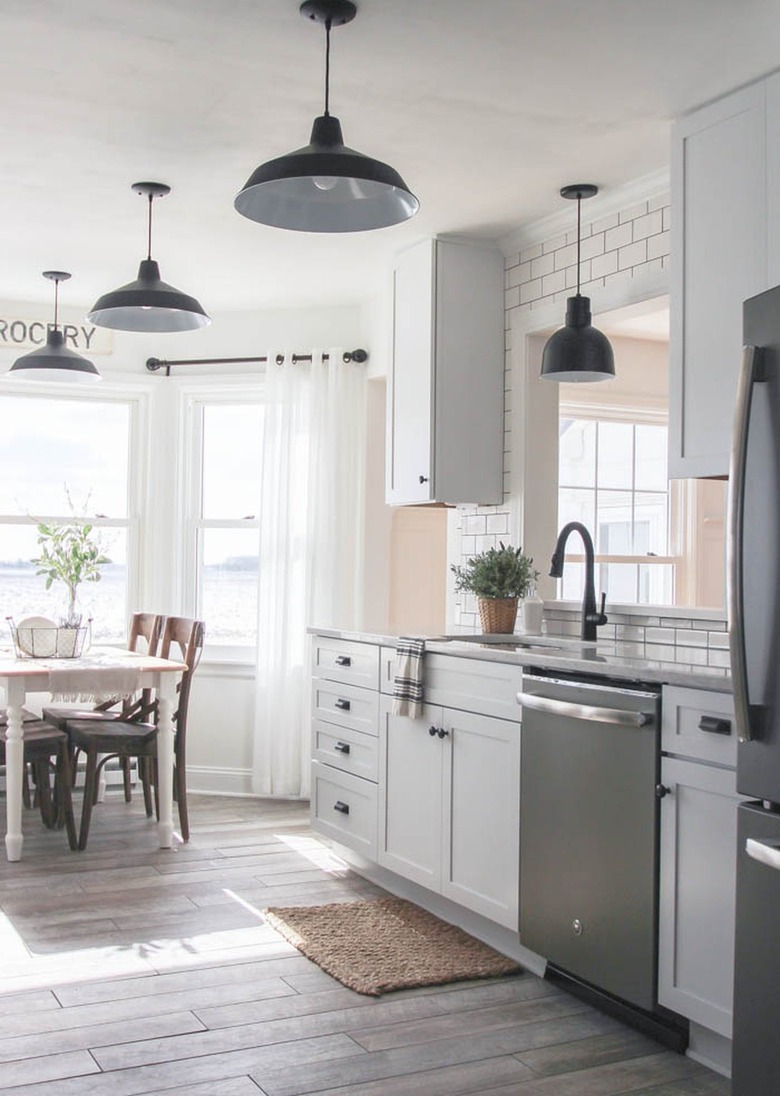 farmhouse kitchen and dining area with black pendant lights