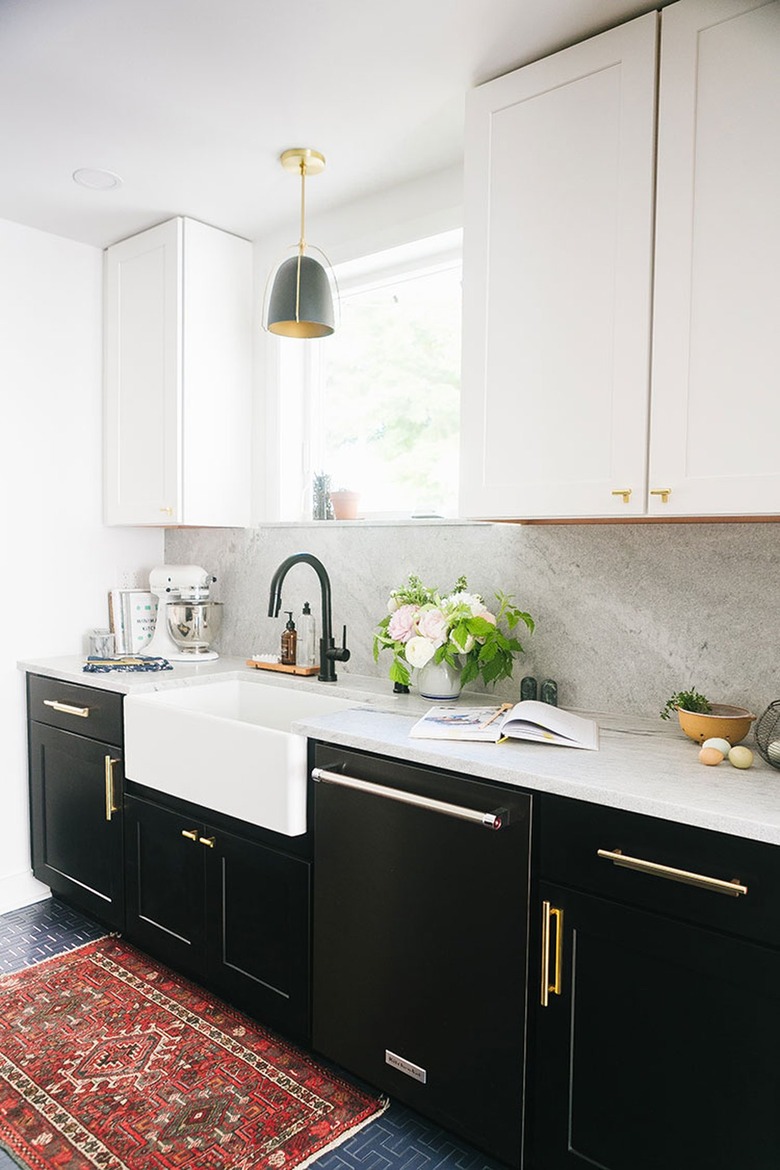 brass and black farmhouse kitchen with vintage rug