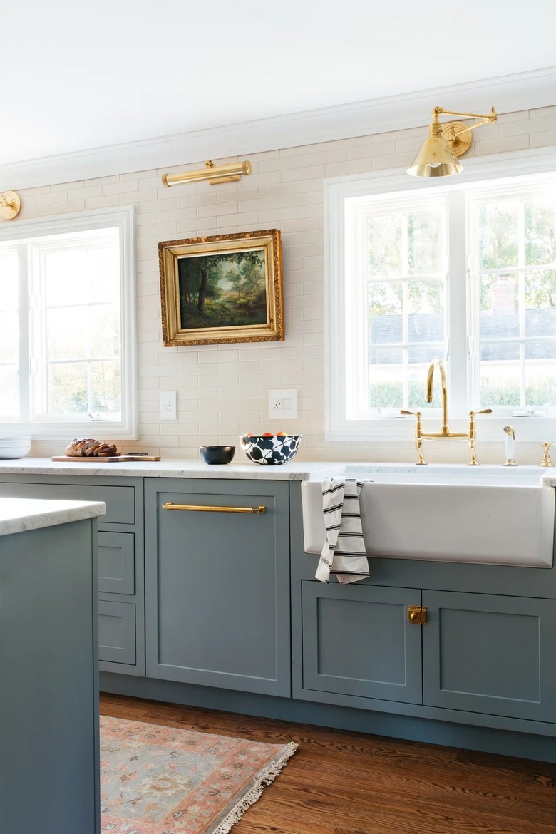 white and blue farmhouse kitchen with oil painting and picture light