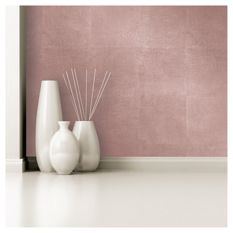 White vases before a rose-gold wallpaper.