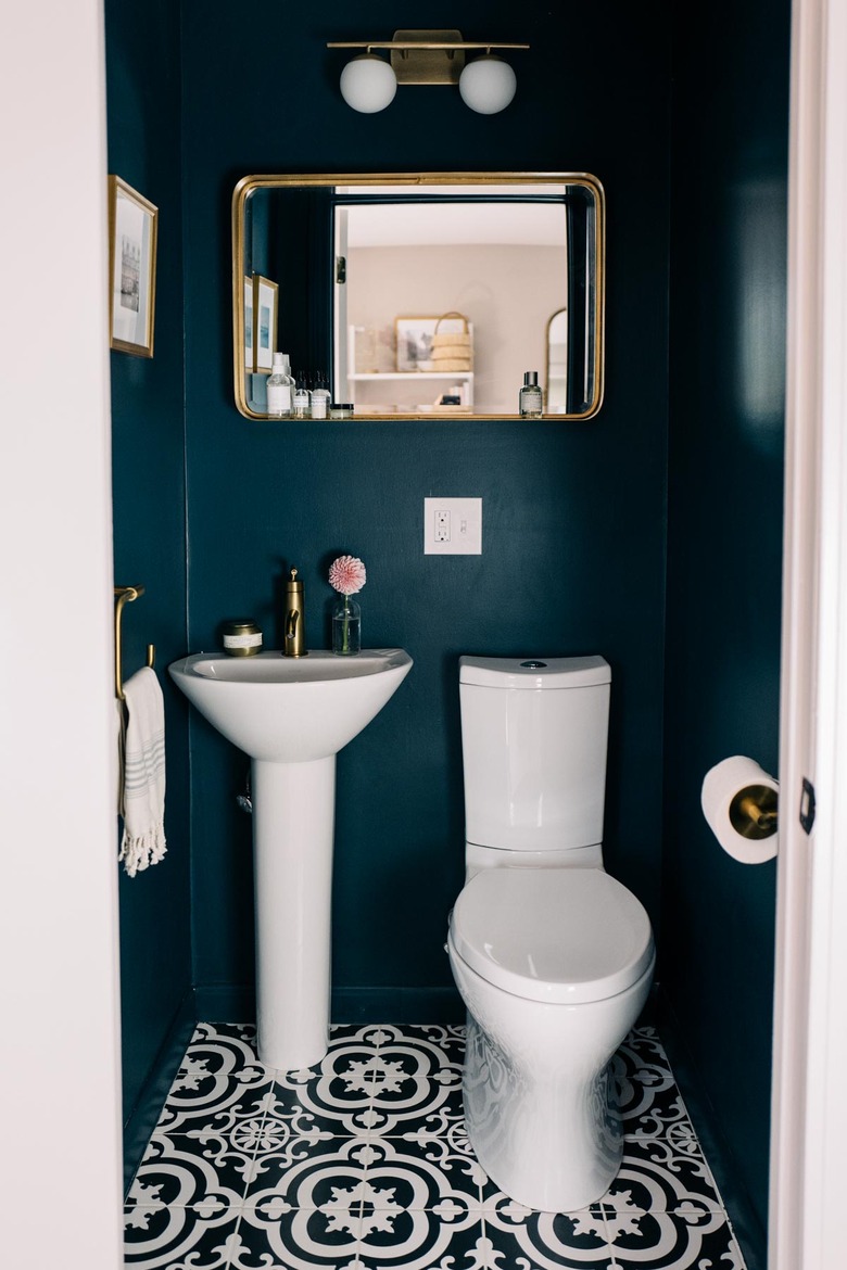 Geometric bathroom pedestal sink with blue walls and patterned floor tile