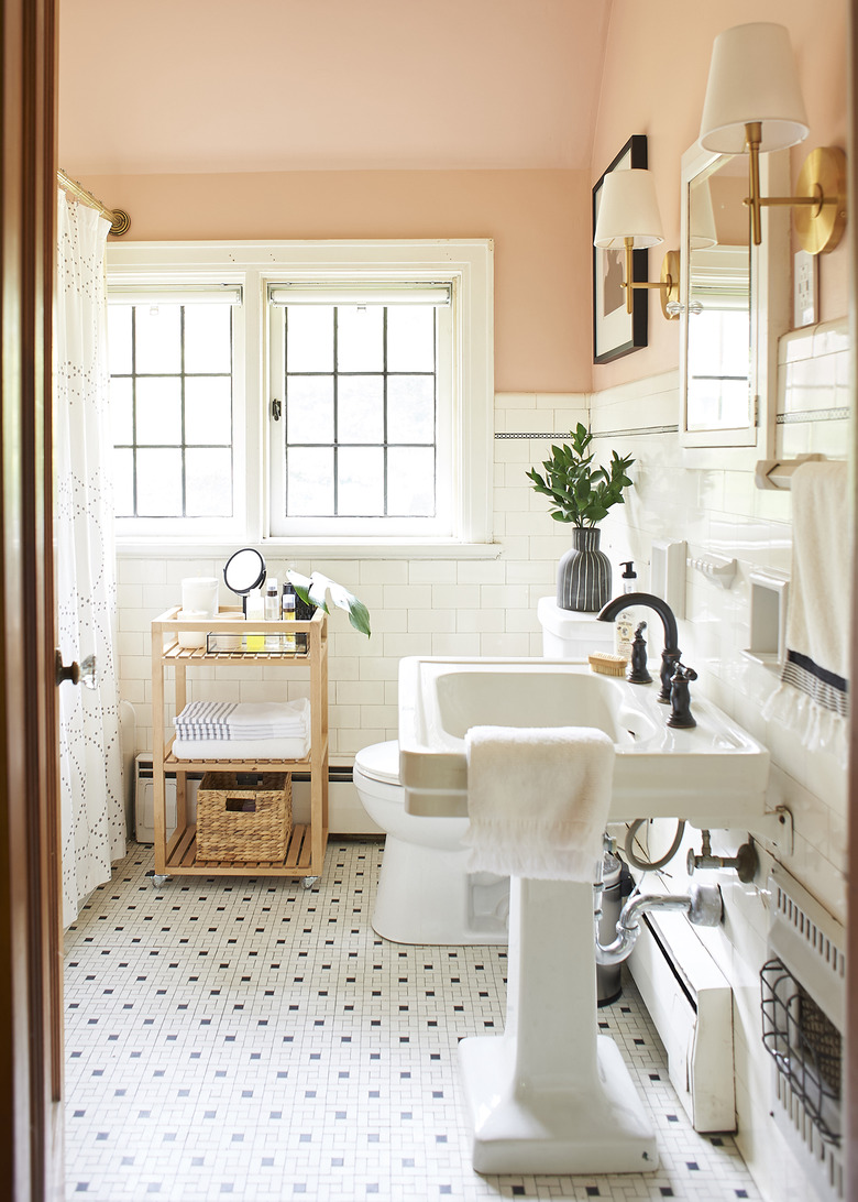 bathroom pedestal sink with white and black mosaic tile flooring and blush walls