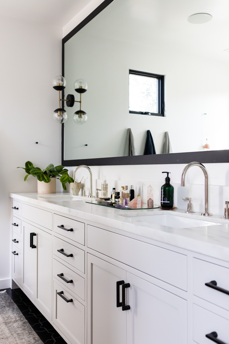 Bathroom with large mirror and sconce on mirror.
