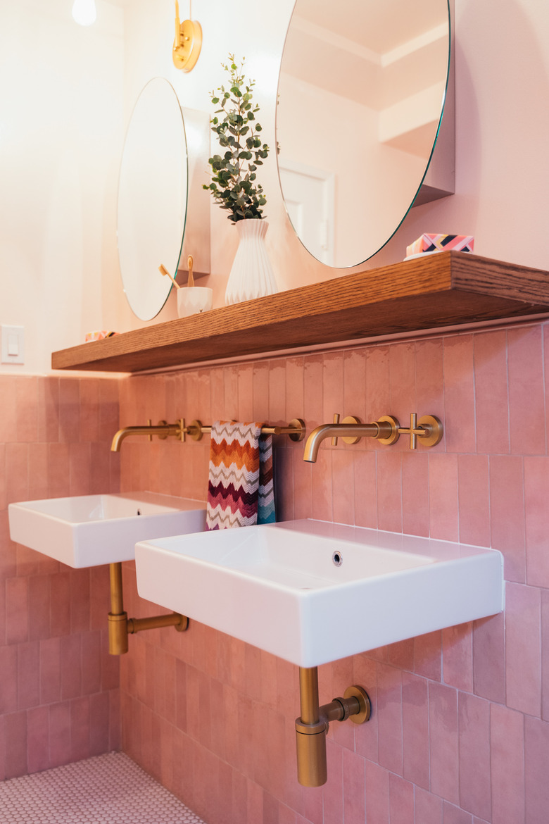 Pink tiled bathroom with wood shelf