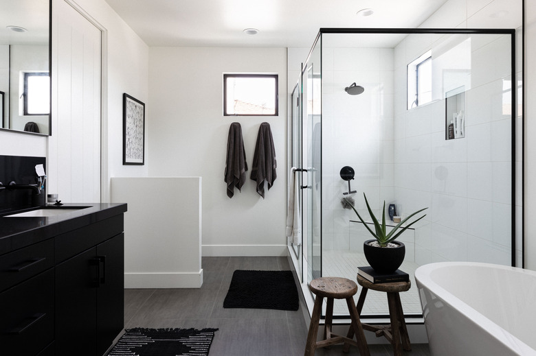 black and white bathroom with tub and glass shower