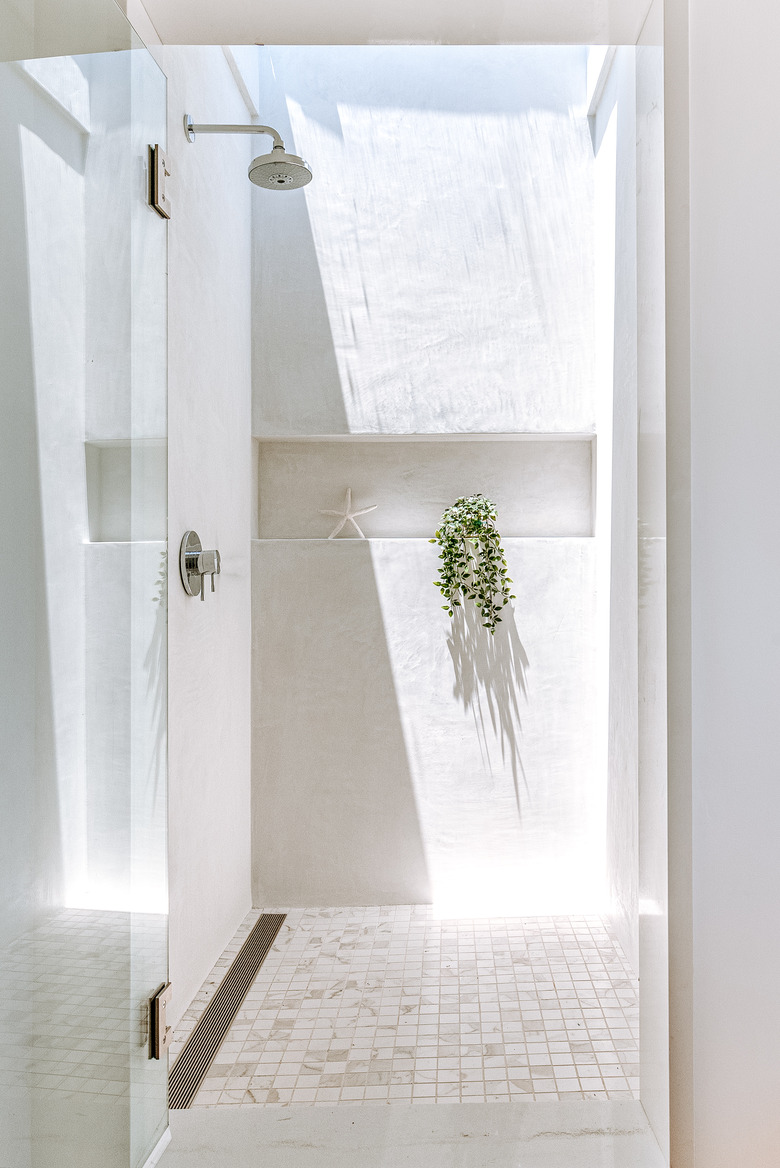 Shower with window on ceiling letting in natural light.
