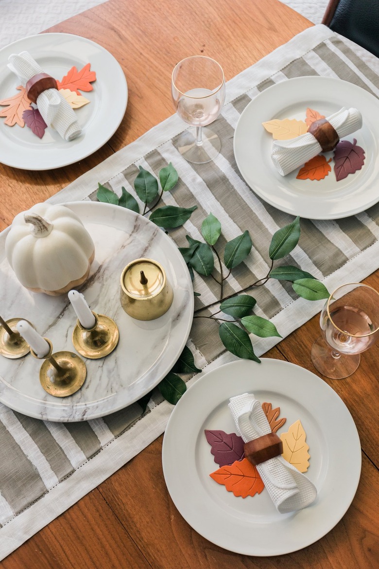 Minimalist striped table runner with dishware and foliage decor