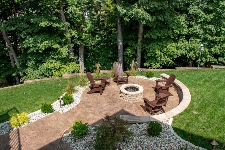 A circular stone patio is surrounded by a garden filled with white rocks