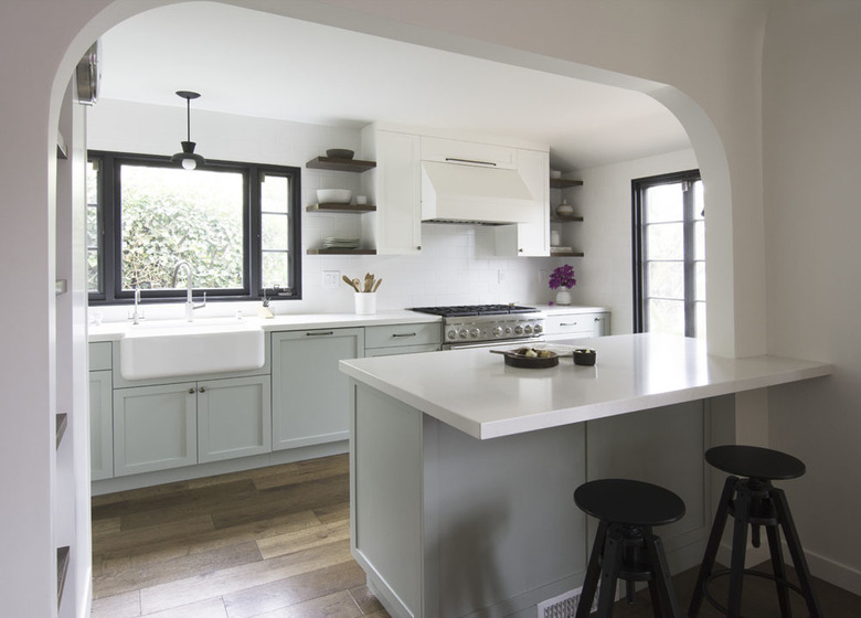 green kitchen cabinets with white countertops and farmhouse sink