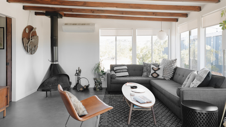modern cabin living room with wood ceiling beams and fireplace