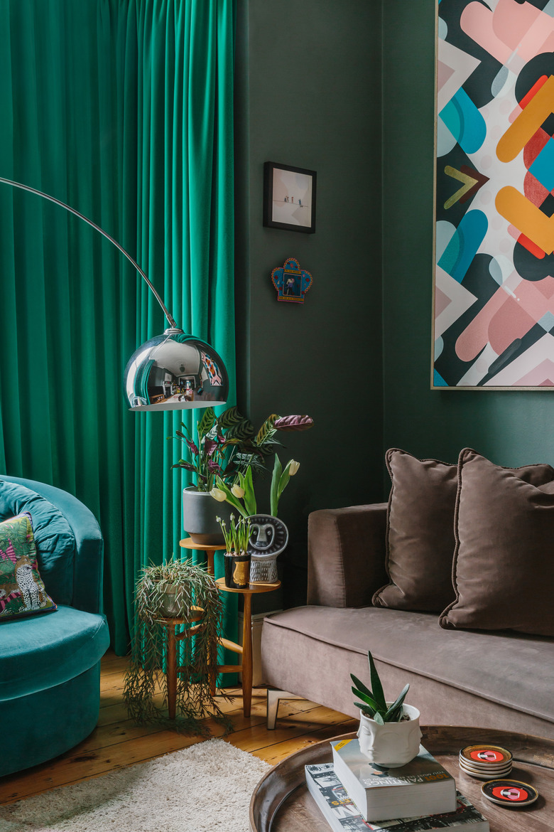 green living room with green velvet curtains and velvet sofa