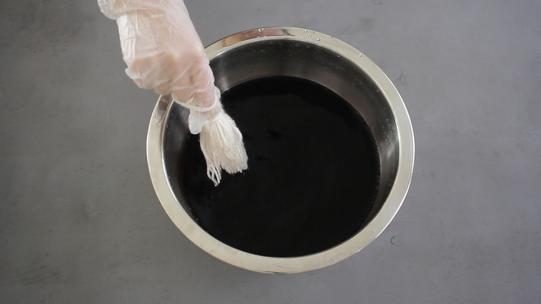 Dipping tassel into black dye