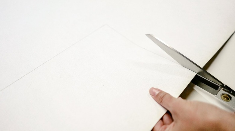 Hands cutting leather with heavy duty shears