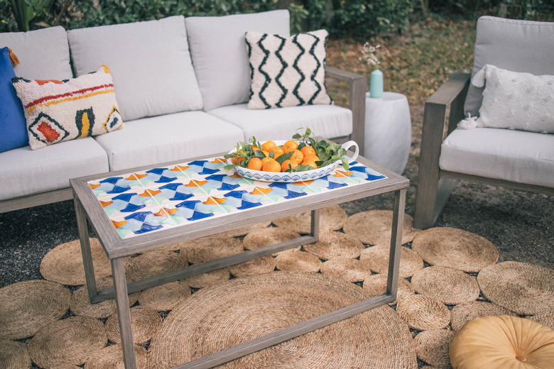 DIY tiled coffee table in outdoor patio with bowl of oranges on top