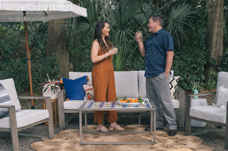 Woman and man standing in outdoor patio with DIY tiled coffee table
