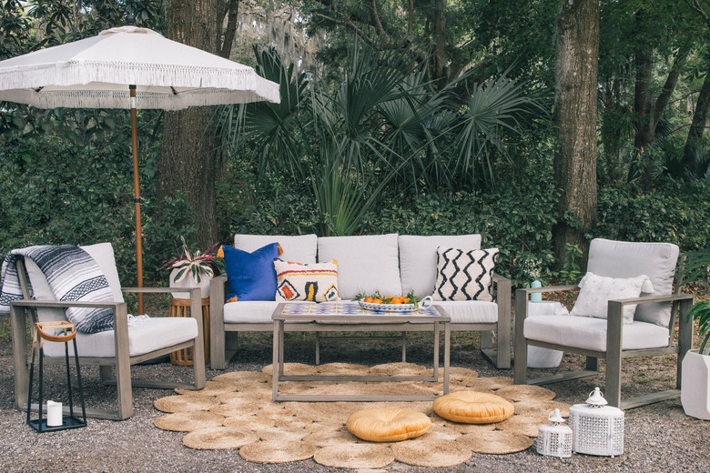 DIY tiled coffee table in in outdoor patio with colorful pillows