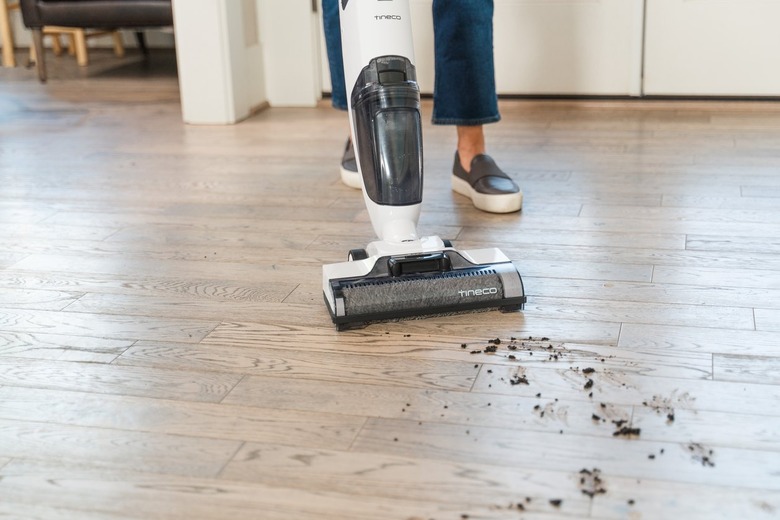 person vacuuming wood floor
