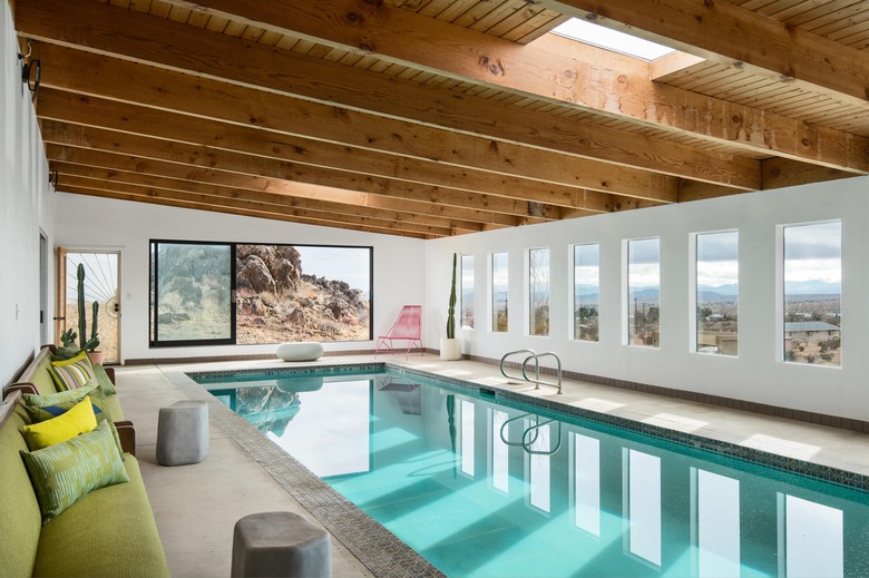 A wide shot of the indoor pool area with wood beamed ceilings