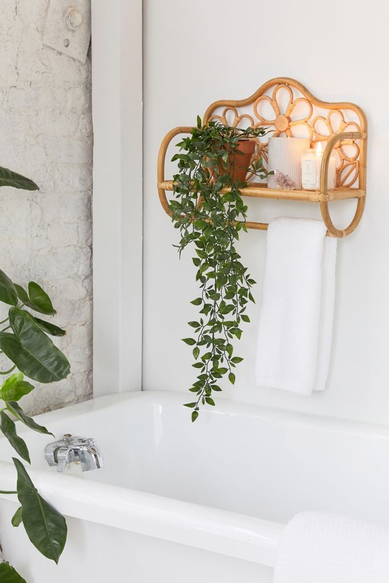 Rattan wall shelf and towel rack for small bathroom with daisy details and houseplant