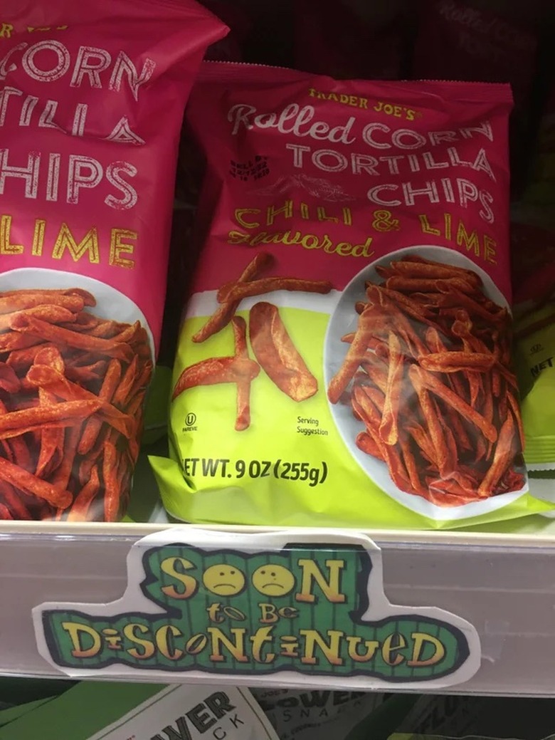 Trader Joe's Chili and Lime Flavored Rolled Corn Tortilla Chips on the shelf with a sign that reads soon to be discontinued