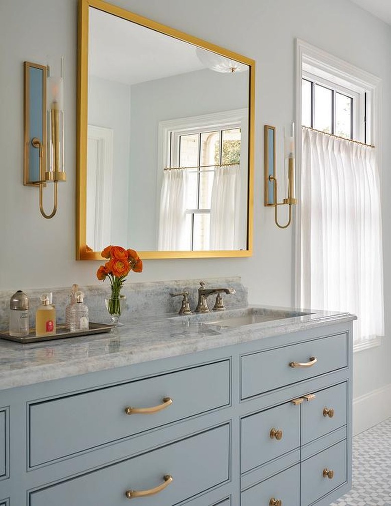bathroom with blue vanity and gold accents