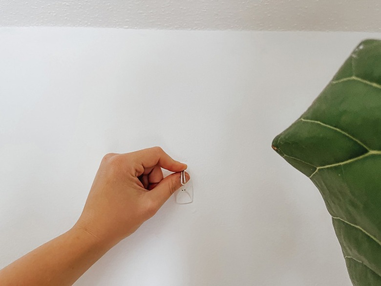 Attach your hook or tap a nail into the wall at that marked spot.