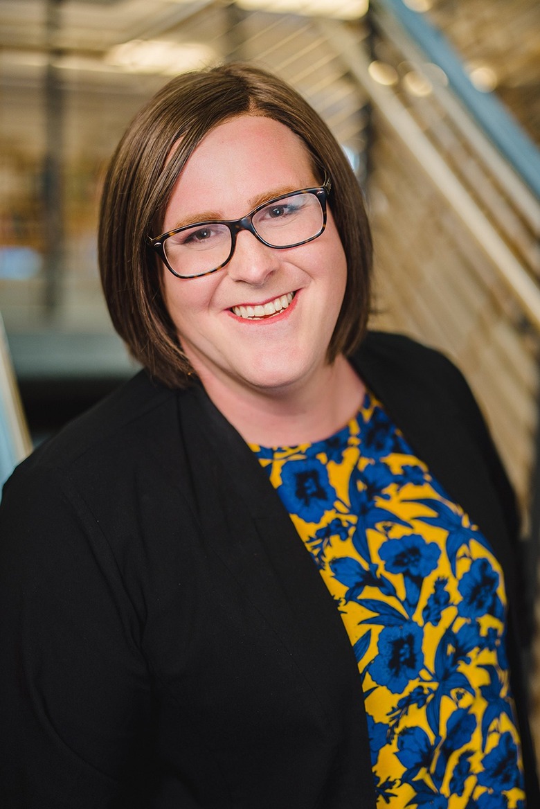 Architect Julia Oderda with brown shoulder-length hair wearing a pair of black glasses