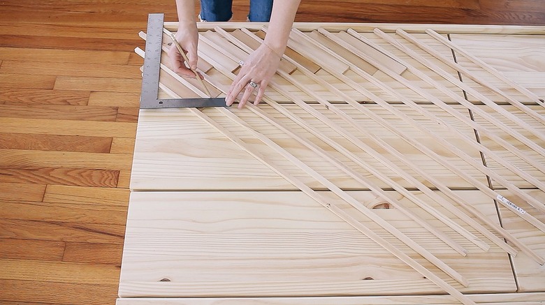 Hands using pencil and ruler on IKEA wood dresser
