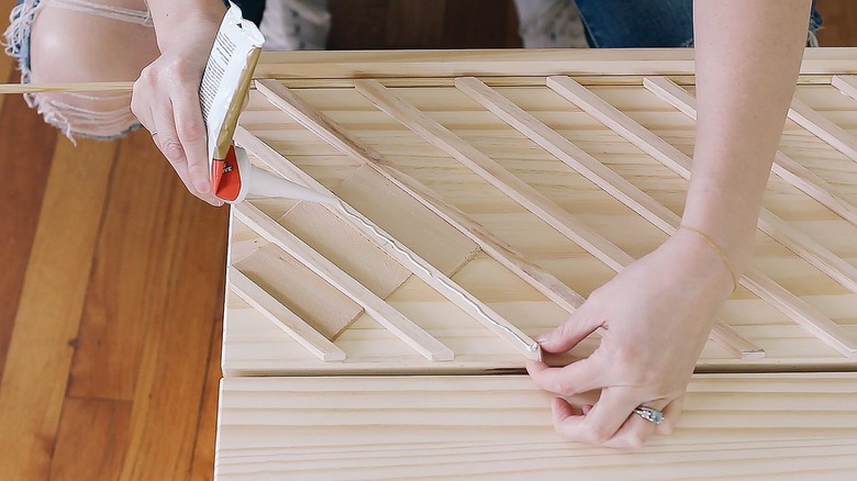 Hands using glue on IKEA wood dresser