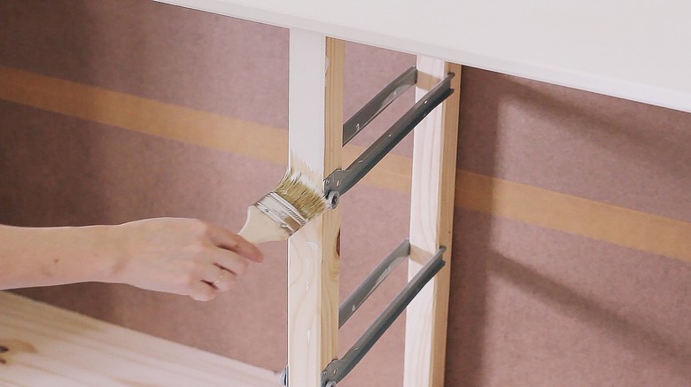 Hand with paintbrush and IKEA wood dresser