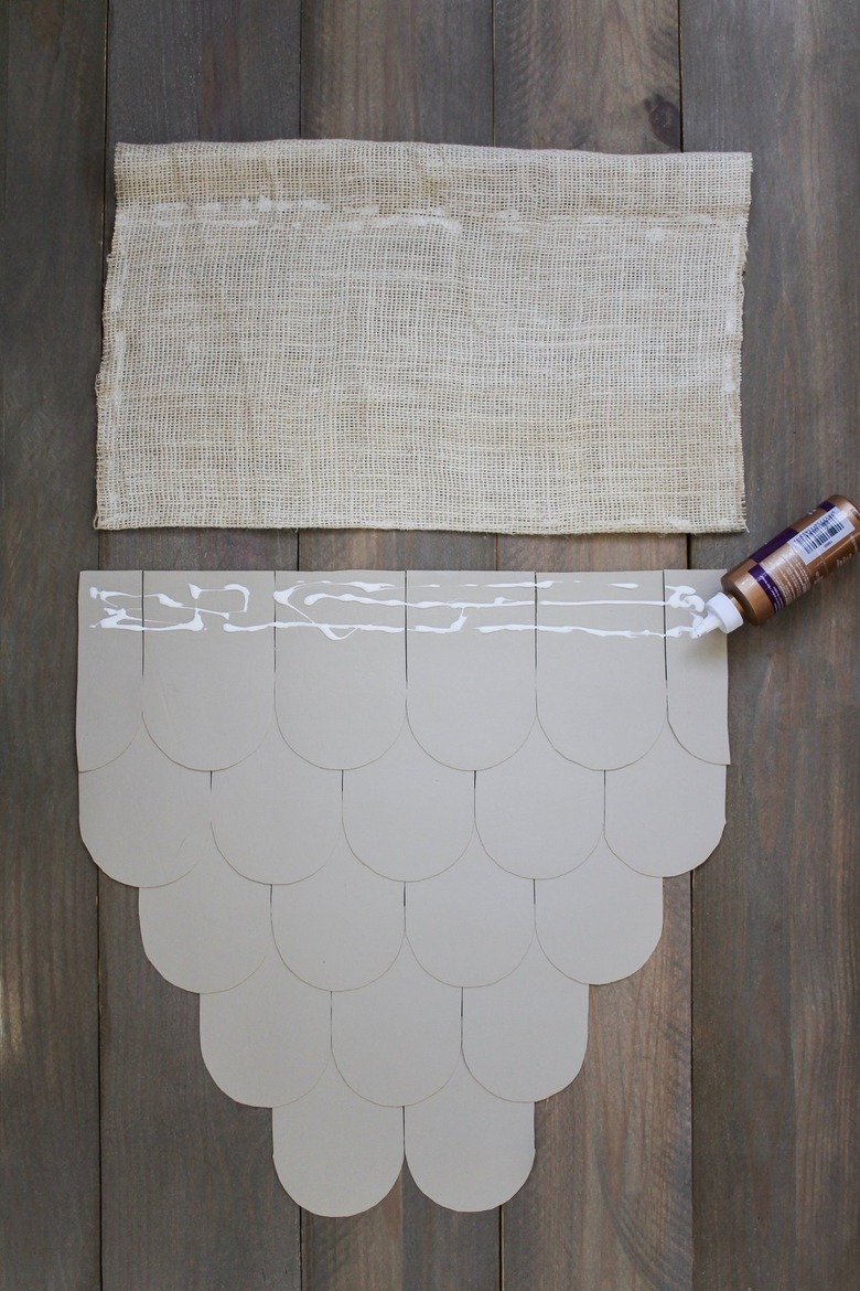 Leather scallops with applied fabric glue and burlap on wood background