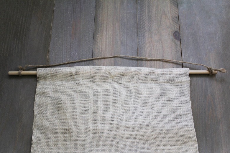 Burlap sheet hanging on wood dowel with twine for hanging