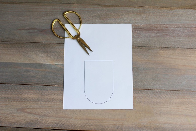 Paper with outlined scallop shape for boho wall hanging with gold scissors